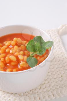 bowl of beans in tomato on white table mat