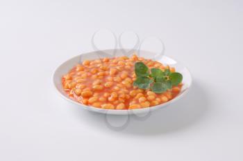 plate of beans in tomato on white background