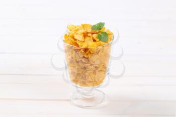 glass of corn flakes on white background