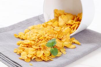 pile of corn flakes spilt out on grey place mat - close up