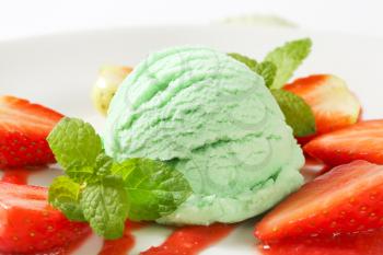 Scoop of green ice cream with fresh strawberries