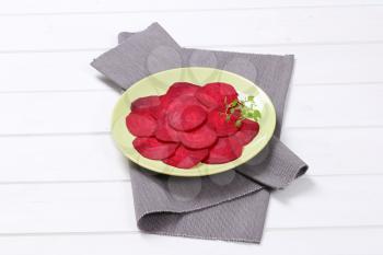 plate of thin beetroot slices on grey place mat