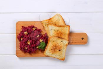 fresh beetroot spread with toast on wooden cutting board