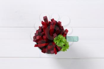 cup of beetroot strips on white wooden background