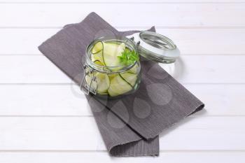 jar of raw zucchini strips on grey place mat