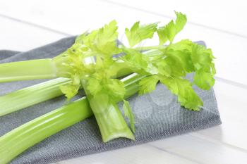 stems of green celery on grey place mat - close up