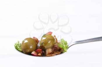 spoon of marinated green olives