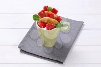 cup of american pancakes with white yogurt and fresh strawberries on grey place mat