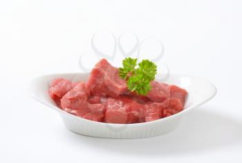 bowl of diced raw beef meat on white background