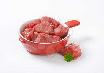 diced raw beef meat with parsley in sauce pan