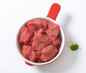 diced raw beef meat with parsley in sauce pan
