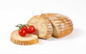 Sliced bread and cherry tomatoes on white background