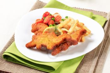 Fried breaded fish served with French fries and mixed vegetables