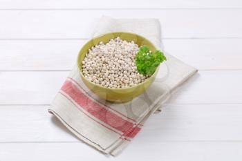 bowl of raw white beans on folded place mat