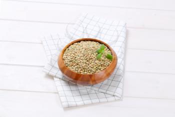 bowl of dry brown lentils on checkered dishtowel