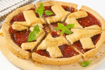 close up of sliced strawberry jam tart with lattice on top