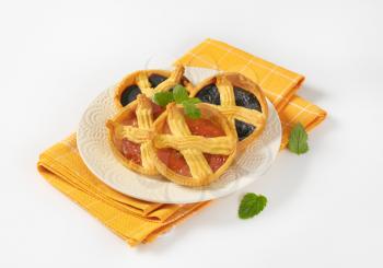 apricot and plum jam tarts on white plate