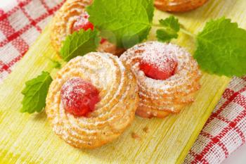 Traditional Sicilian almond cookies topped with glace cherries and sprinkled with powdered sugar