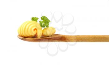 butter curls and fresh parsley on wooden spoon
