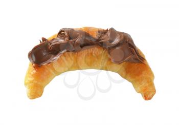 croissant topped with chocolate cream on white background