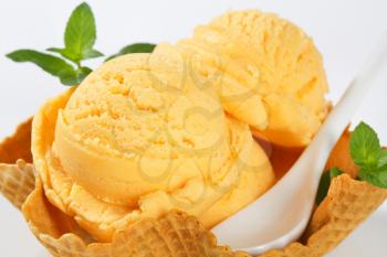Scoops of orange ice cream in a waffle basket