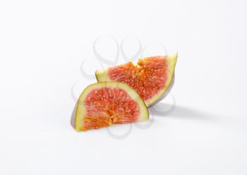 two slices of ripe fig on white background