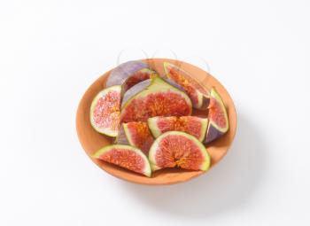 bowl of fresh sliced figs on white background