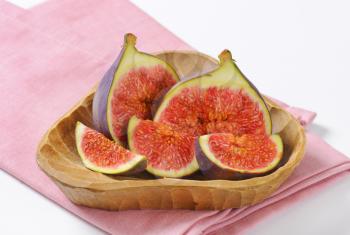 bowl of fresh sliced figs on pink napkin - close up