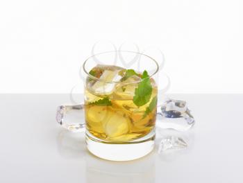 glass of apple juice with ice on white background