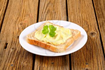 Slice of toast bread with butter on a plate