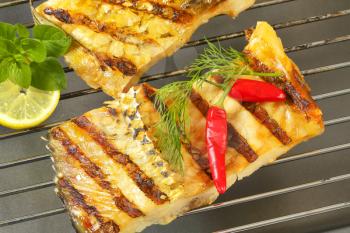 Grilled carp fillets on barbecue grill