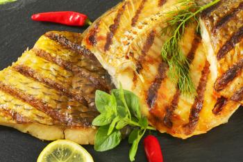 Grilled carp fillets with lemon, herbs and red chili pepper