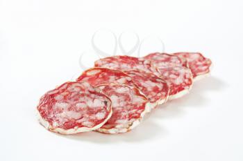 Sliced French dry sausage (Saucisson Sec)  on white background