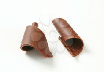 Two chocolate curls on white background