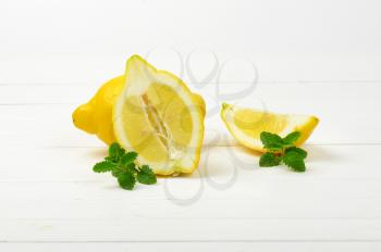 whole and sliced lemons on white wooden background