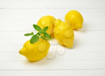 fresh juicy lemons on white wooden background