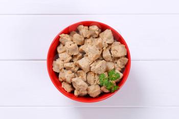 bowl of soy meat cubes on white wooden background