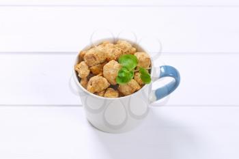 mug of soy meat cubes on white wooden background