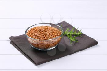 bowl of raw buckwheat on grey place mat