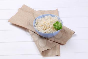 bowl of cooked rice pasta fusilli on beige place mat