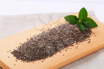 pile of chia seeds on wooden cutting board - close up