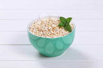 bowl of puffed buckwheat on white wooden background