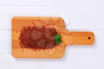 pile of red rice on wooden cutting board