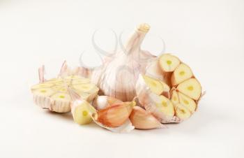 bulbs and cloves of fresh garlic on white background