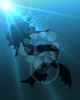 Beautiful long haired mermaid in deep water against sun beams.