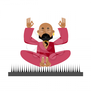 Yogi on nails. Indian yogi sits on spike. nirvana Meditation. Man practicing yoga exercises. Bald man with beard meditates