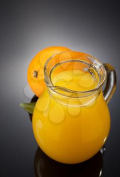 orange juice and fruit on black background