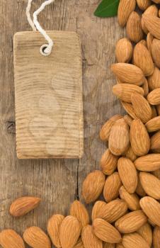 nuts almond fruit and tag label on wood background texture