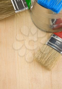 paintbrush and can on wood background texture