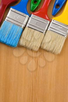colorful paintbrush on wood background texture